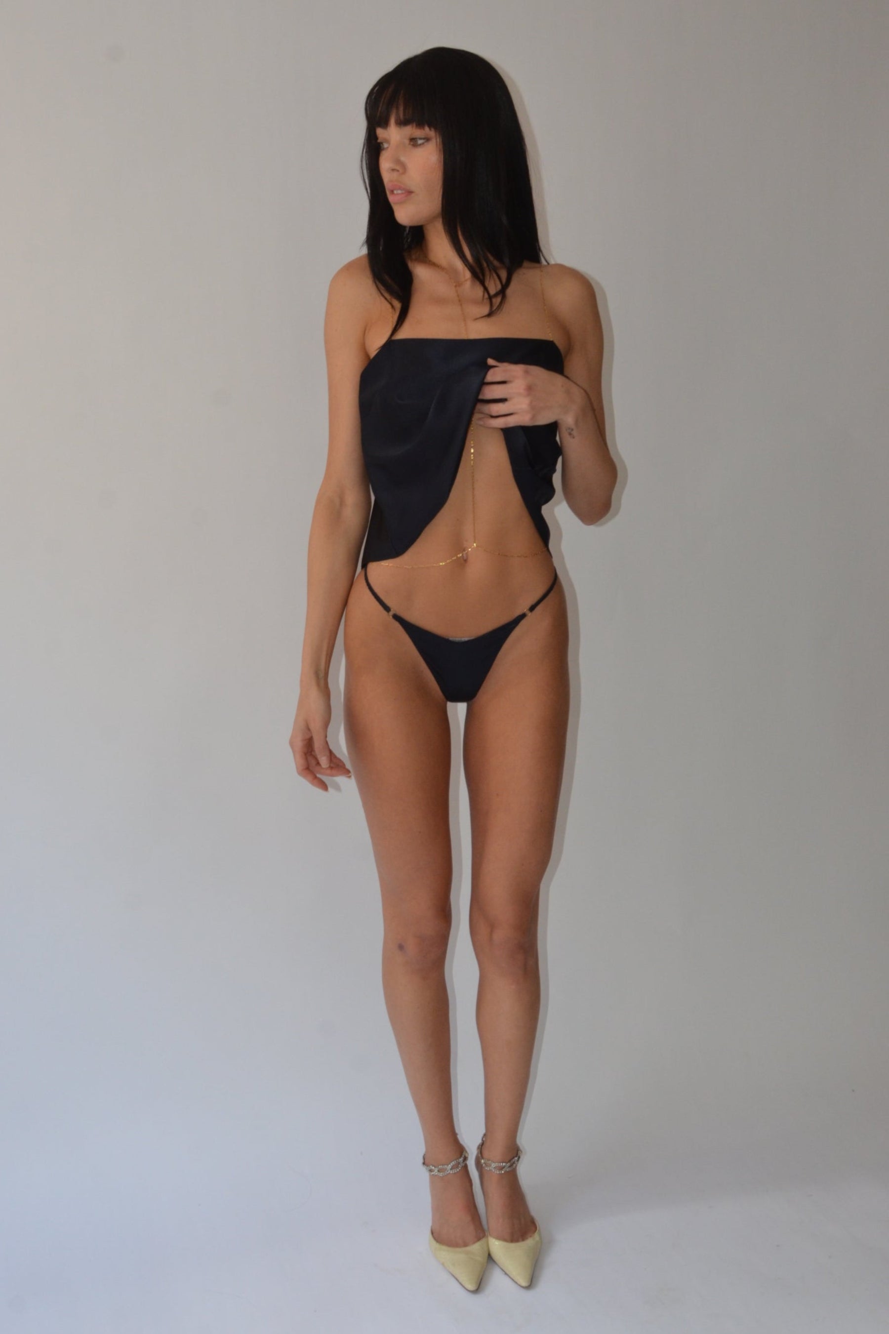 Woman wearing a navy top and thong on a white background