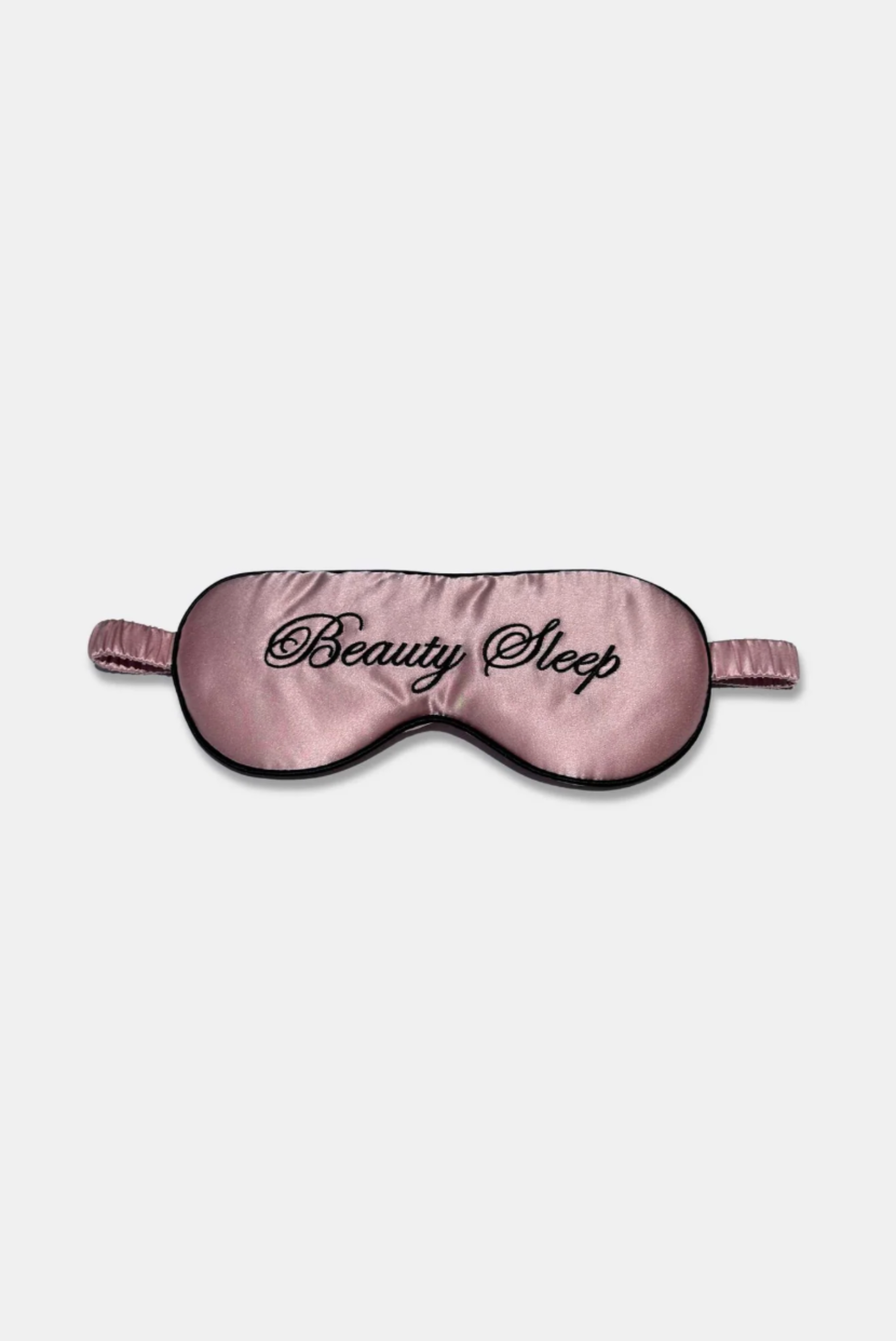 Pink satin sleep mask with 'Beauty Sleep' text on a white background
