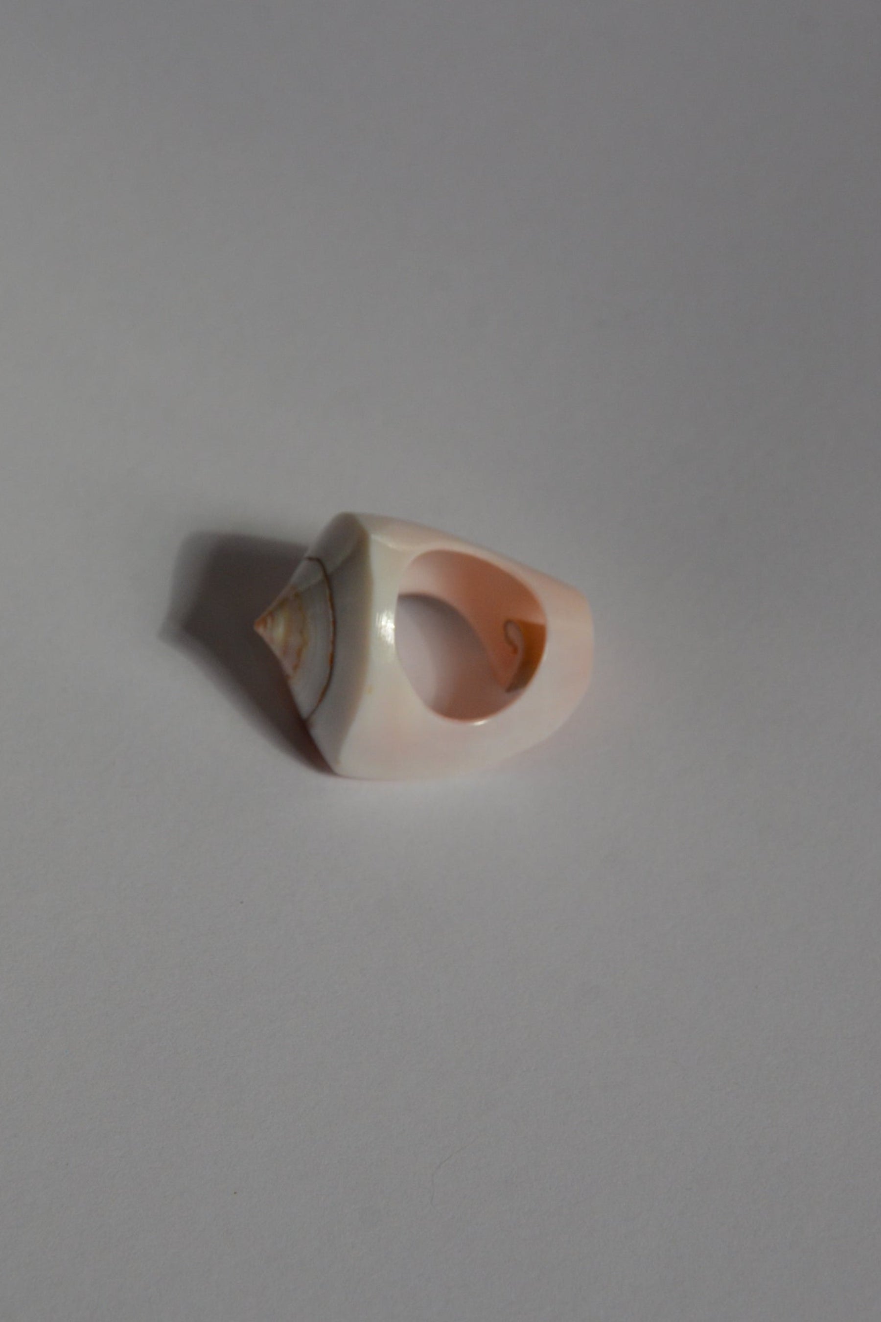 White ring with a pink interior on a light gray background