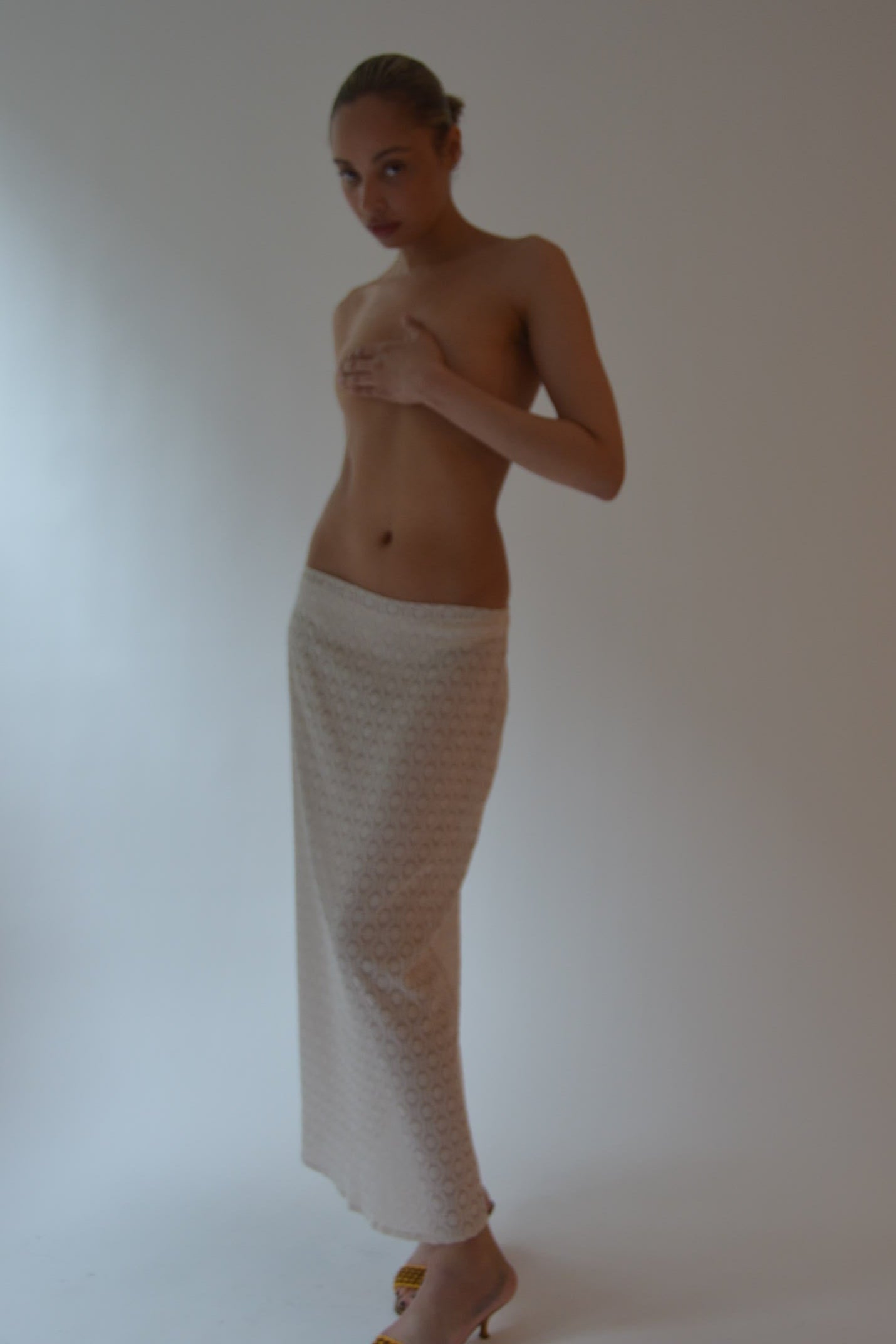 Person lying on a white sheet against a plain background